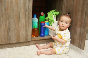 Little girl playing with detergents in kitchen