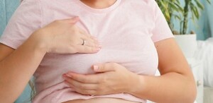 Young pregnant woman with big belly checking and touching her breast before lactation. Concept of pregnancy healthcare and medical examination