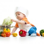 baby chef with healthy  food vegetables and pan